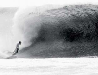 A man surfing a large wave in the ocean